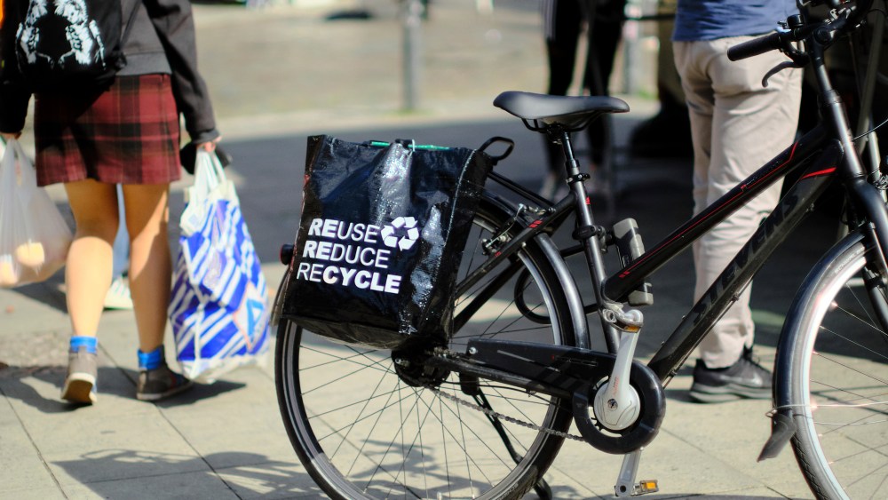 24 August 2021, Berlin: A bicycle with the lettering "REUSE. REDUCE. RECYCLE" and the logo for recycling stands at the weekly market on Maybachufer in the Neuk'lln district. Photo by: Stefan Jaitner/picture-alliance/dpa/AP Images