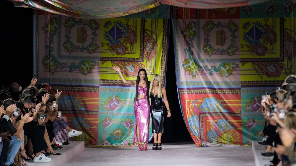 Dua Lipa, left, and Donatella Versace acknowledge applause at the conclusion of the Versace Spring Summer 2022 collection during Milan Fashion Week, in Milan, Italy, Friday, Sept. 24, 2021. (AP Photo/Luca Bruno)