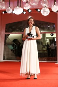 Maggie Gyllenhaal holds the Best Screenplay award for 'The Lost Daughter' after the closing ceremony of the 78th edition of the Venice Film Festival in Venice, Italy, Saturday, Sept. 11, 2021. (Photo by Joel C Ryan/Invision/AP)