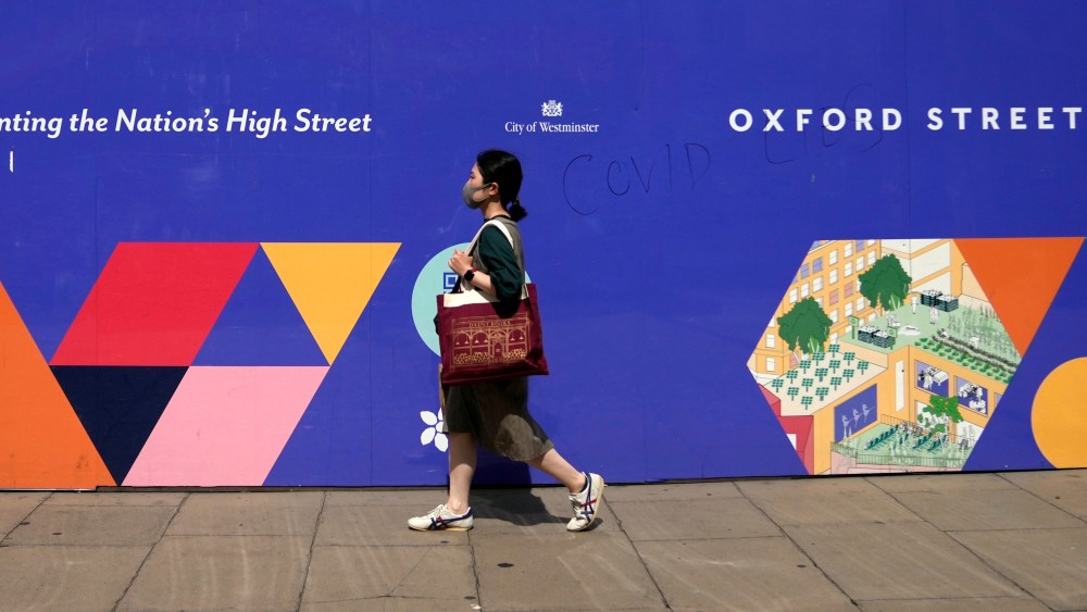 A woman walks along Oxford Street while wearing a face mask against the coronavirus in London.
