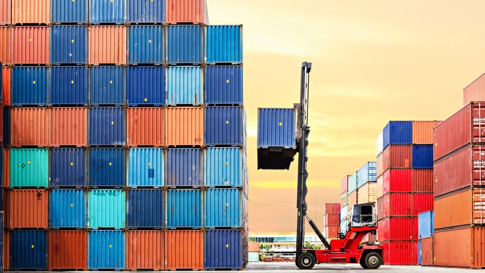 Crane lifting up container in yard