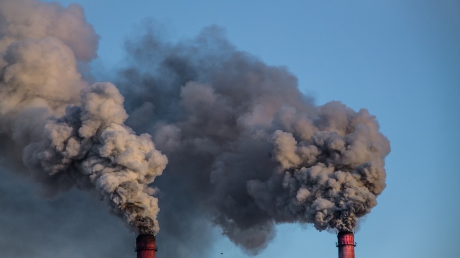 industrial chimneys with heavy smoke causing pollution on the blue sky background