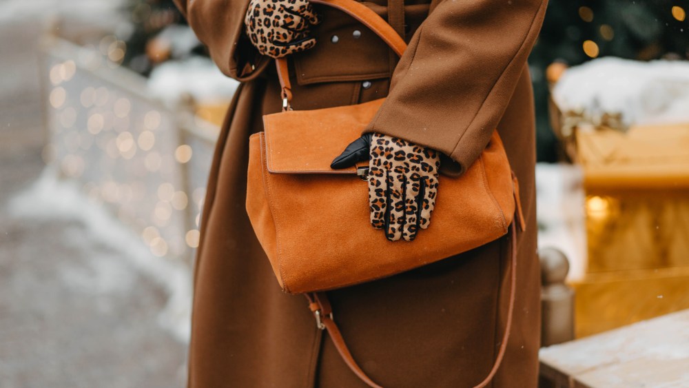 Outdoor fashion portrait of plus size woman wearing trendy animal, leopard print. Concept of autumn and winter clothes, outfit for glamour woman in city. Background of Christmas decorations. Copy space.