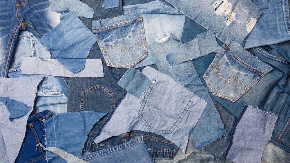 Old denim garbage background. Recycling old jeans. Old blue jean