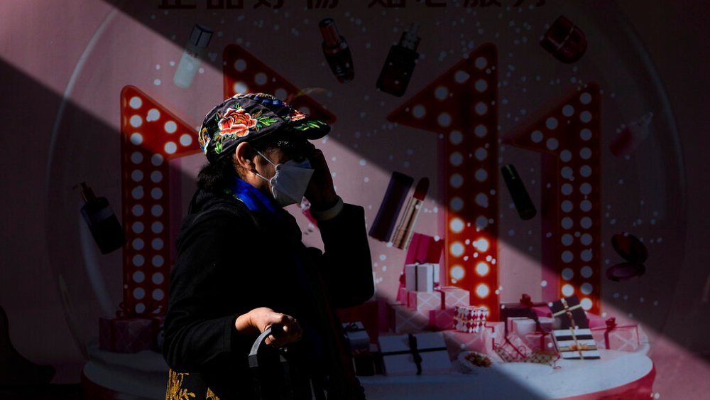A woman walks past an advertisement for Singles Day or 11/11.