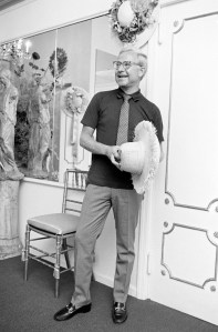 Designer Adolfo poses at his New York City atelier with a hat design from his Summer 1968 collection