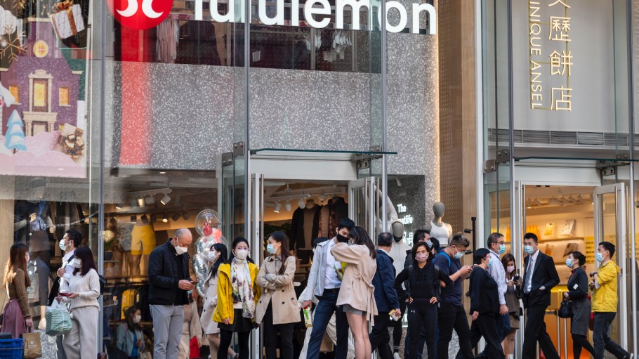 Pedestrians walk past the Canadian sportswear clothing band, Lululemon store in Hong Kong.