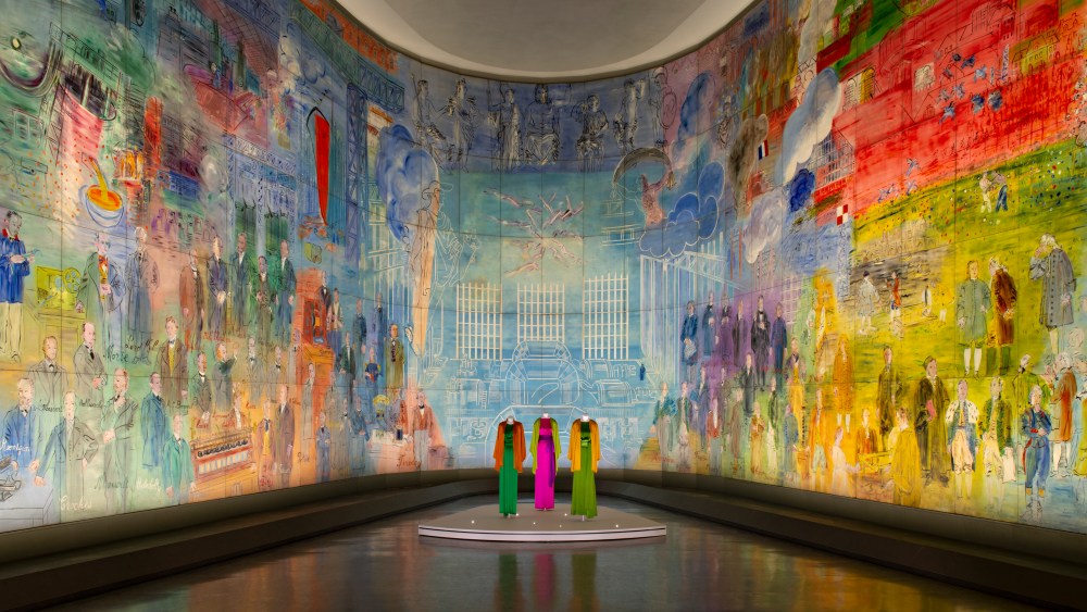 Yves Saint Laurent designs in front of Raoul Dufy’s “The Electricity Fairy” at the Paris Museum of Modern Art.