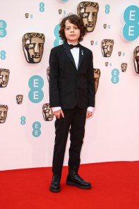 Woody Norman poses for photographers upon arrival at the 75th British Academy Film Awards, BAFTA's, in London Sunday, March 13, 2022. (Photo by Joel C Ryan/Invision/AP)