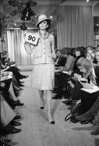 A model poses in Chanel's classic knit suit and accessories from the Chanel Spring 1972 haute couture collection fashion show. This collection was designed with artistic director Gaston Berthelot.