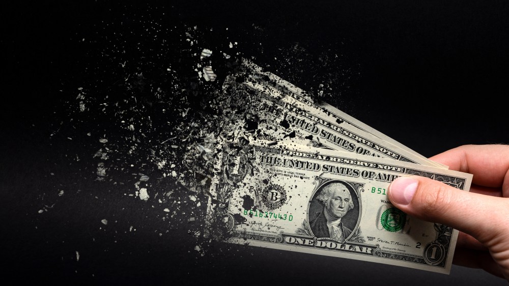 Inflation, dollar with black background. One dollar bill is sprayed in the hand of a man on a black background. The concept of decreasing purchasing power, inflation