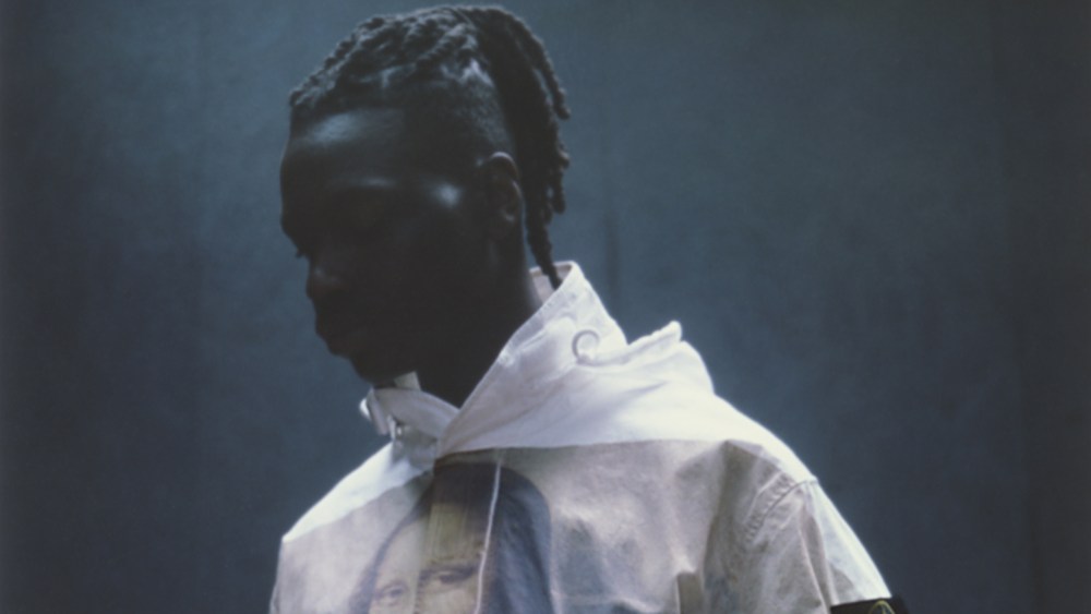 A look at the new Stone Island/Supreme collection features a man wearing a hoodie coat with the Mona Lisa on the front.