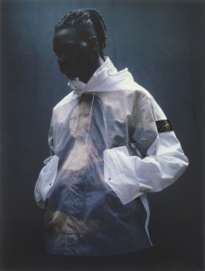 A look at the new Stone Island/Supreme collection features a man wearing a hoodie coat with the Mona Lisa on the front.