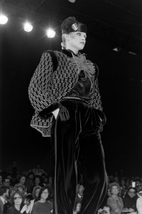 A model poses in a sweater jacket and velvet tuxedo pants from Valentino's RTW Fall 1979 collection runway show in Paris.