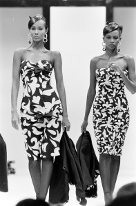 Models Iman and Amalia Varielli walk the runway in printed dresses from Valentino's Spring 1985 Couture collection.