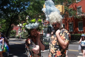 With toppling-over wigs, two men arrive to Washington Square Park to celebrate Pride.