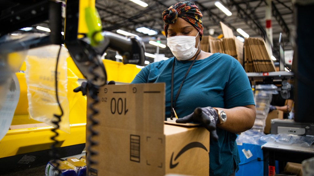 woman with box in amazon fulfillment center