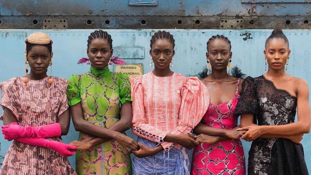 Five well-dressed Black models holding hands in Lagos.