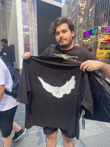 A shopper holding up his newly purchased Dove No Seam Tee from the Gap flagship.