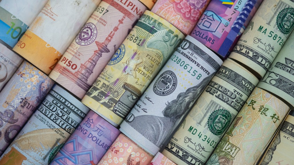 Closeup rolled of variety banknote around the world. Exchange rate and Forex investment concept.-Image.