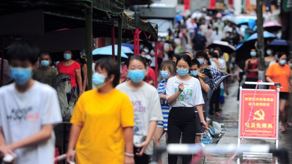 Residents and tourists queue to undergo nucleic acid tests for the Covid-19 coronavirus in Sanya in China's southern Hainan province on August 8, 2022.