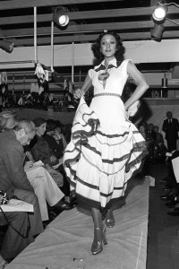 Model Norma Jean Darden walks the runway in a ribbon trimmed dress from designer Giorgio di Sant'Angelo's Spring 1974 ready to wear collection. The fashion was presented at the designers design studio and workroom in New York City's Garment District.