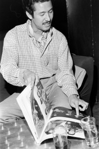 Designer Issey Miyake with a copy of his book "East Meets West" during pre-setup for his fashion show and celebration of Studio 54's Anniversary party, 1978.