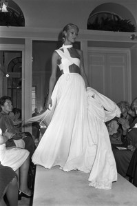 A model wears a white pleated evening gown from Madame Gres' Fall 1977 couture collection