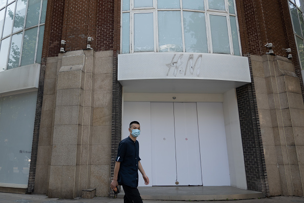 A man walks by the closed H&M flagship store in Shanghai.