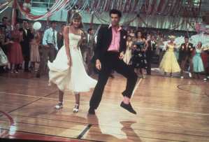 Australian singer and actress Olivia Newton-John and American actor John Travolta dance in a crowded high school gym in a still from the Paramount film, 'Grease', 1978. (Photo by Paramount Pictures/Fotos International/Getty Images)