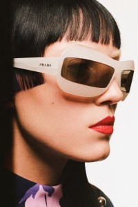 Prada’s acetate eyewear. Carolina Herrera polyester dress.