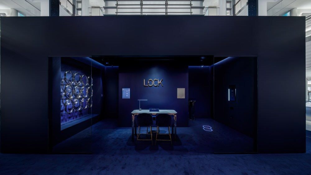 Tiffany & Co. 'Lock' pop-up features an all sapphire blue shop-in-shop with a table and the words 'Lock' on the wall.