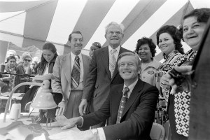 Members of the IGLWU (International Garment Ladies Workers Union and guest watch as Mayor John Lindsay and dress union boss Murray Gross perform a sewing demonstration, 1972.