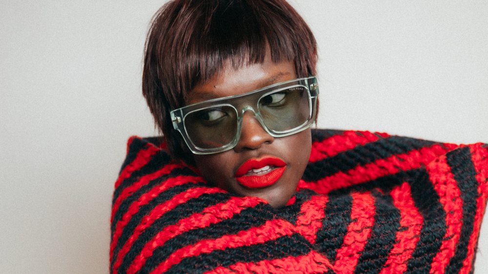 Colored frame: Tom Ford’s Fausto acetate sunglasses. Alaïa knitted scarf coat.