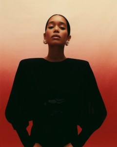 Saint Laurent's jersey jumpsuit with ruched rose detail. Miu Miu earrings.