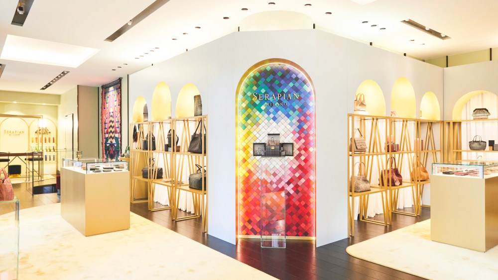 Inside Serapian's pop-up store on rue de la Paix in Paris features central arch with colorful mosaic tiles and handbags are displayed on shelves under other arches in the walls throughout the store