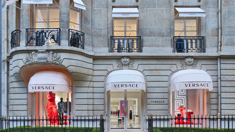 Versace's flagship storefront in Paris features three windows with visible Versace product.