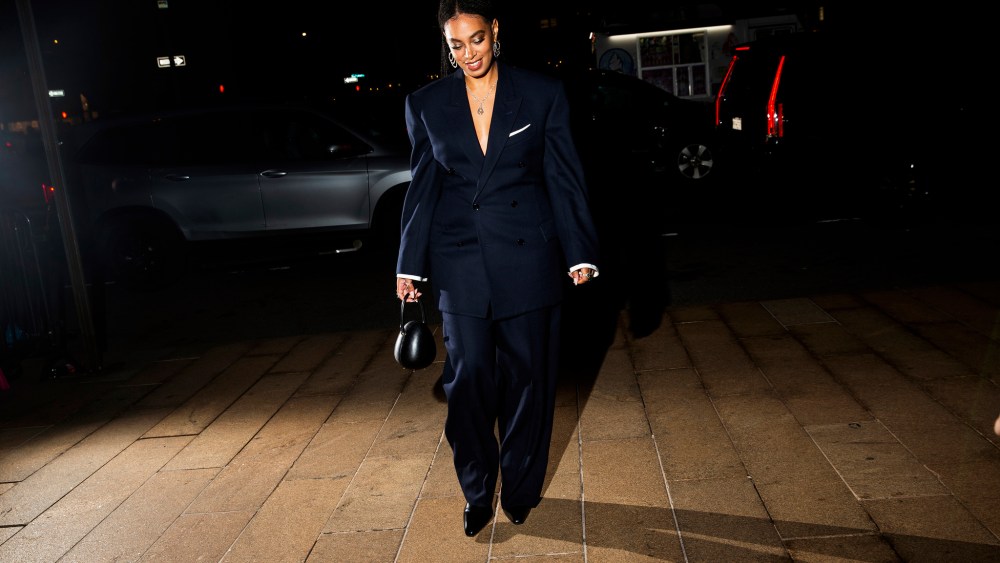 Solange walking with cars behind her