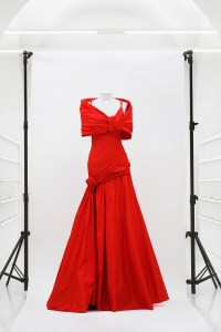 A red gown with bow detail at shoulders and draping at hips from Valentino's Prêt-À-Porter Fall-Winter 2007-08, mod 80.