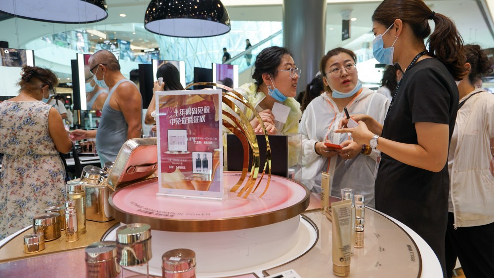 Customers shop for cosmetics at Sanya International Duty-Free Shopping Complex.