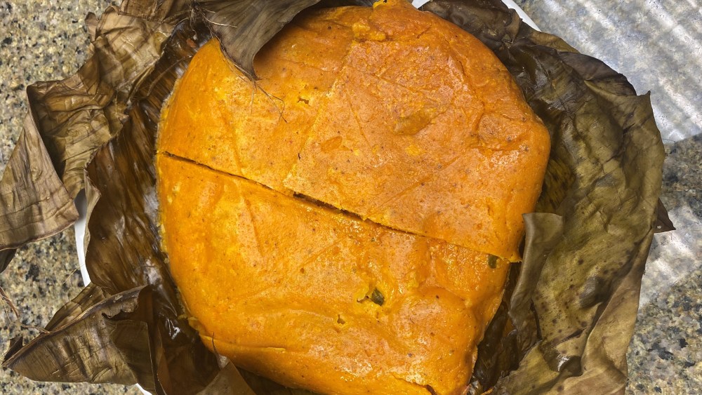 Mukbil pollo, as prepared by Chef Sergio Zárate features a bird's eye view of the large tamal resting on banana leaves.