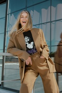 Khaite’s wool drape jacket and pants with stylist’s own vintage T-shirt and belt. Isabel Marant boots; Joanna Laura ring.