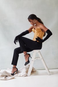 Schiaparelli’s satin corset and wool pants. Alaïa gloves; Givenchy pumps. Boucheron Serpent Bohème Solarité multimotif hoop earrings, set with round diamonds, on yellow gold.