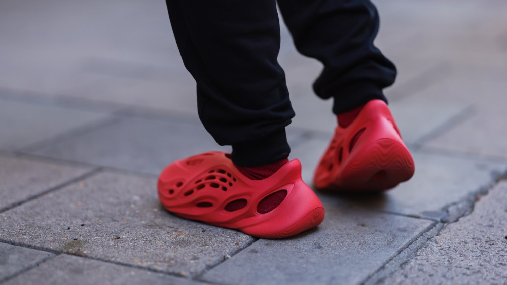 A Fashion Week guest seen wearing red Adidas Yeezy shoes during London Fashion Week on Sept. 17, 2022 in London, England.