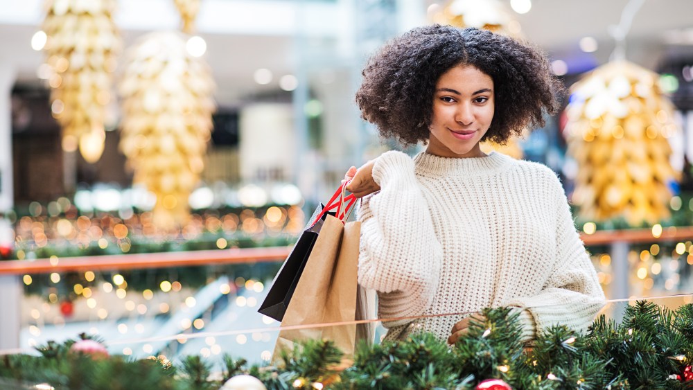 A portrait of happy teenage girl with paper bags in shopping center at Christmas.