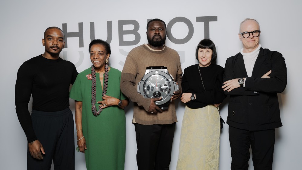Nifemi Marcus-Bello, center holding a giant Hublot watch, with Hublot Design Prize judges Samuel Ross, Marva Griffin Wilshire, Alice Rawsthorn, and Hans Ulrich Obrist.