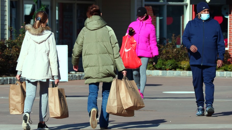 CENTRAL VALLEY, NY - NOVEMBER 24: People carry shopping bags at the Woodbury Common Premium Outlets shopping mall on November 24, 2020 in Central Valley, New York.