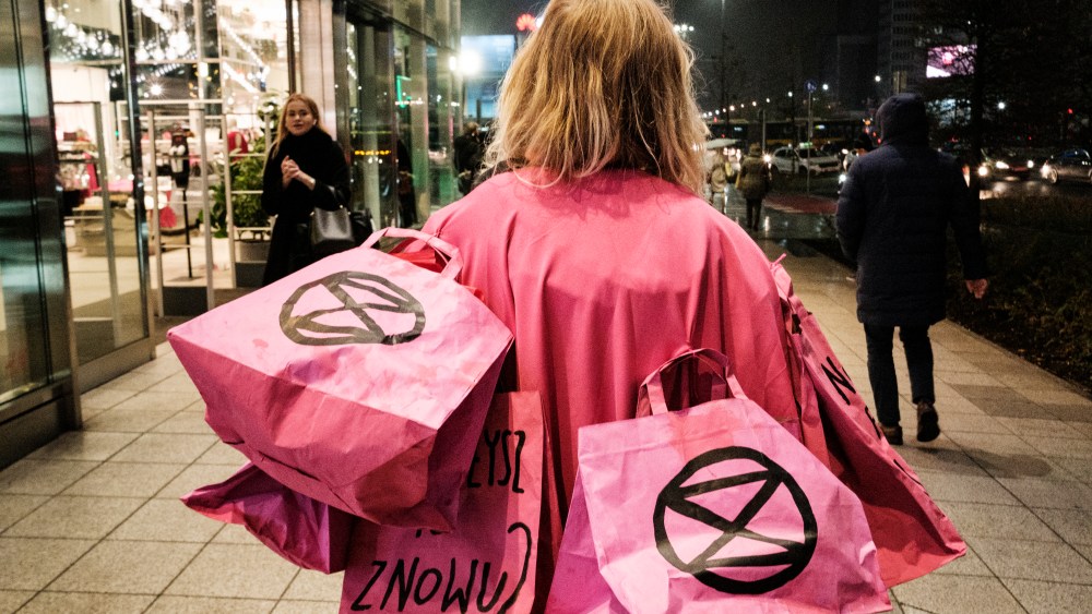 Extinction Rebellion protesting against Black Friday & Fast Fashion in Warsaw, Poland. Climate activists gathered in front of one of Warsaw city center's shopping malls. Pair of protesters also glued themselves to the shopping window inside of H&M store. Activists protested against "Black Friday" sales and "fast fashion" in general - rapidly changing trends, pushing consumers to shop for new cloths every season. The key challange XR members raised was high usage of water during production process, high CO2 trace as most of clothing factories are placed on far east, and oil based fabrics used for production, causing high plastic polition. Warsaw, Poland, on November 25th, 2022. (Photo by Piotr Lapinski/NurPhoto via AP)