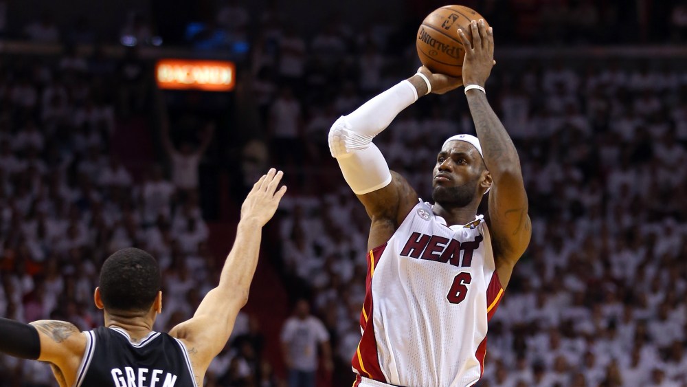 LeBron James of the Miami Heat makes a three-pointer over Danny Green of the San Antonio Spurs in the second quarter during Game Seven of the 2013 NBA Finals.