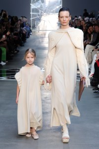 BERLIN, GERMANY - JANUARY 17: Models walk the runway at the VORN -The Berlin Fashion Hub x NEWEST runway show, adult model wears a dress by Anna Girey, coat, bolero by Pugnat, panties, shirt by Tindi, shoes by Trippen, and the child wears a dress by Pugnat, shoes are stylist's own, during the Berlin Fashion Week AW23 at Kant-Garagen on January 17, 2023 in Berlin, Germany. (Photo by Andreas Rentz/Getty Images for NEWEST 2023)